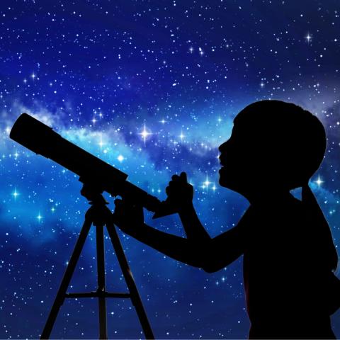 A person with a telescope silhoutted against the Milky Way.