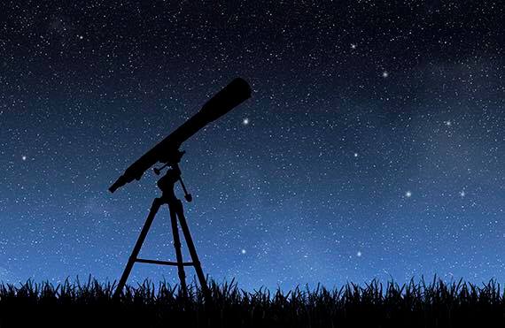 Telescope silhouette against a starry sky