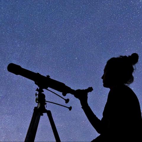 Person looking through telescope