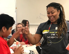 Scientist and student fist-bumping