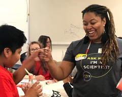 A scientist interacting with students during a SciMatch visit
